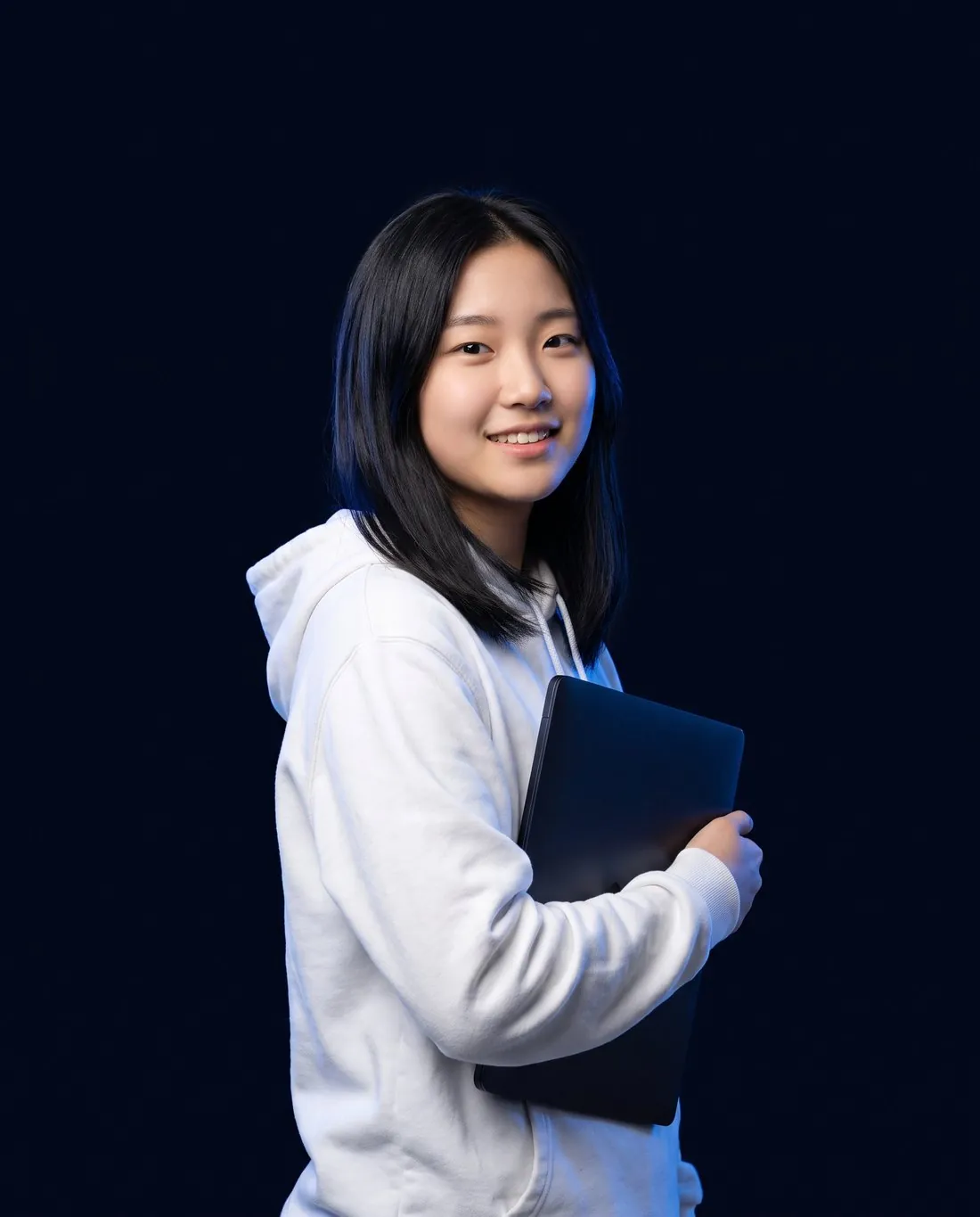 Student holding a laptop, studying for the SAT online